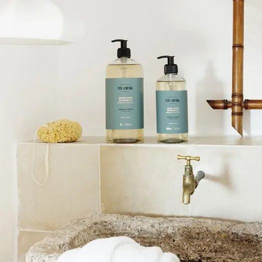 Afbeelding van twee flessen vloeibare zeep met de geur Embruns et Cédrat in scène gezet