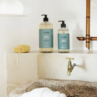 Afbeelding van twee flessen vloeibare zeep met de geur Embruns et Cédrat in scène gezet